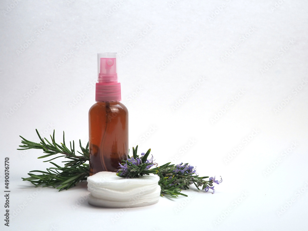 Rosemary tonic for face or hair. Spray bottle, sprigs of natural rosemary and cotton pads. Isolated on white background