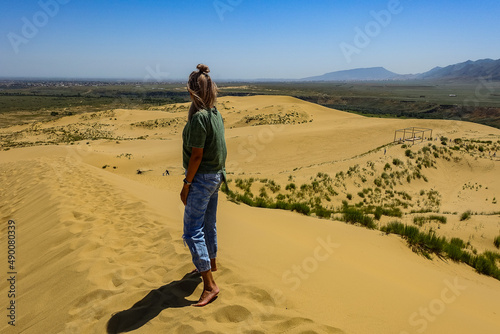 A girl on the sand dunes of Sarykum. The desert in Dagestan. Russia. 2021.