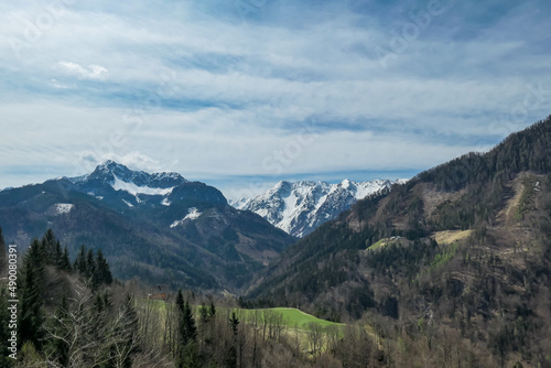 Scenic view of snow capped mountain peaks of Karawanks near Sinacher Gupf in Carinthia, Austria. Mount Wertatscha and Hochstuhl (Stol) is visible in early spring. Hills in Rosental on sunny day. Hike © Chris