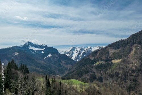 Scenic view of snow capped mountain peaks of Karawanks near Sinacher Gupf in Carinthia, Austria. Mount Wertatscha and Hochstuhl (Stol) is visible in early spring. Hills in Rosental on sunny day. Hike