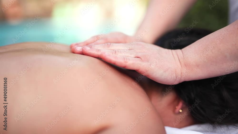 Stone pebble massage therapy on upper back macro shot Stone pebble massage therapy on upper back macro shot