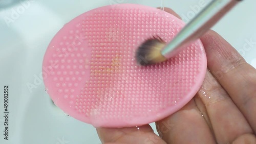 cleaning the brush after makeup on a silicone sponge