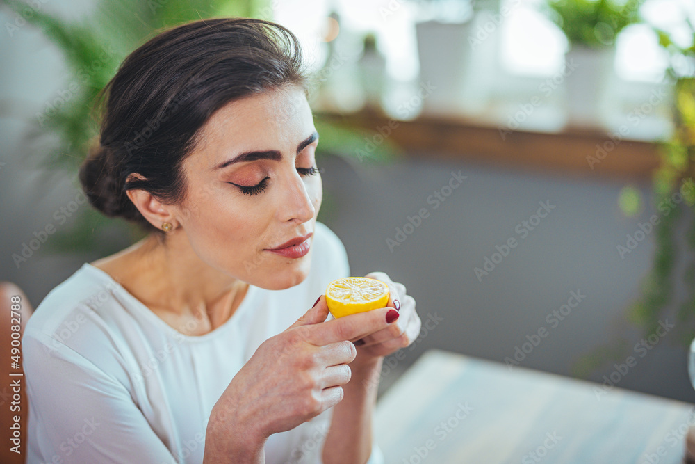 Sick woman trying to sense smell of half fresh lime, has symptoms of Covid-19, corona virus infection - loss of smell and taste. One of the main signs of the disease. Sick woman trying to sense smell of half fresh lime, has symptoms of Covid-19, corona virus infection - loss of smell and taste. One of the main signs of the disease.