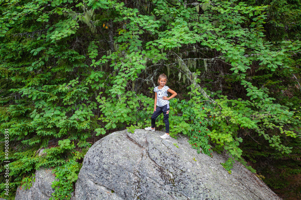 Portrait of smiling little girl at rock formation at forest. Summer day in nature. Active child. Portrait of smiling little girl at rock formation at forest. Summer day in nature. Active child.