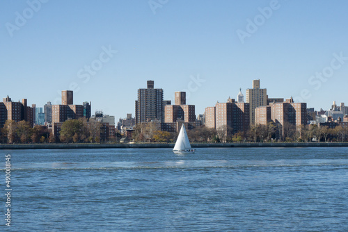 A sail boat makes its way down the East River, New York City.