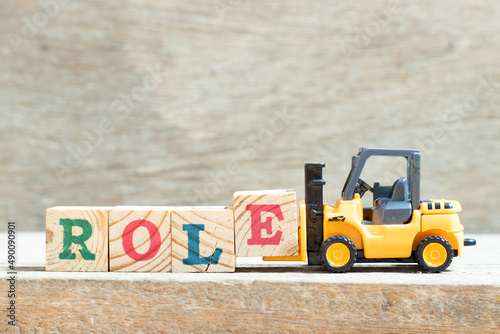 Quadro em tela Toy forklift hold letter block e to complete word role on wood background