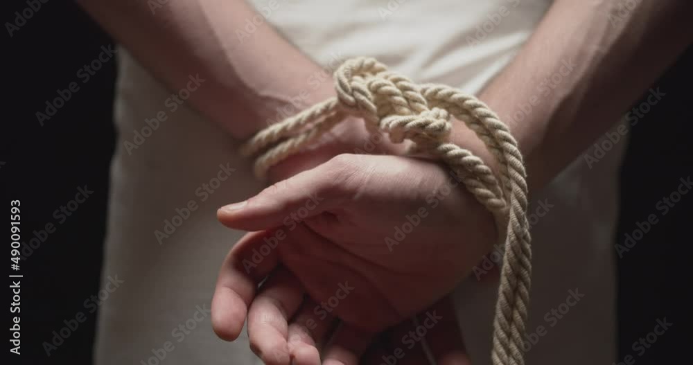 Man with the hands tied by a rope dropping three arrows