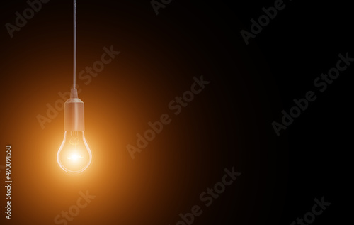 electric incandescent lamp on a black background with an orange halo