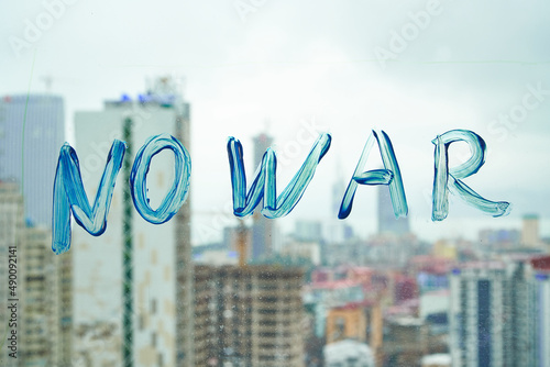 No war. Letters on the window in blue paint. Stop war. support for Ukraine. text on the background of the city.