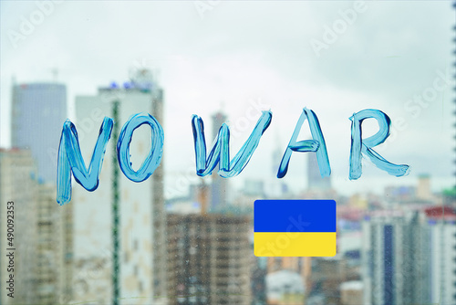 No war. Letters on the window in blue paint. Stop war. support for Ukraine. text on the background of the city.