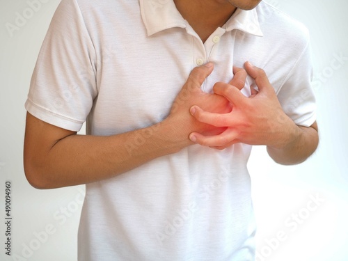 Asian man having severe chest pain as heart attack and illness concept on white background. closeup photo, blurred. © Bungon