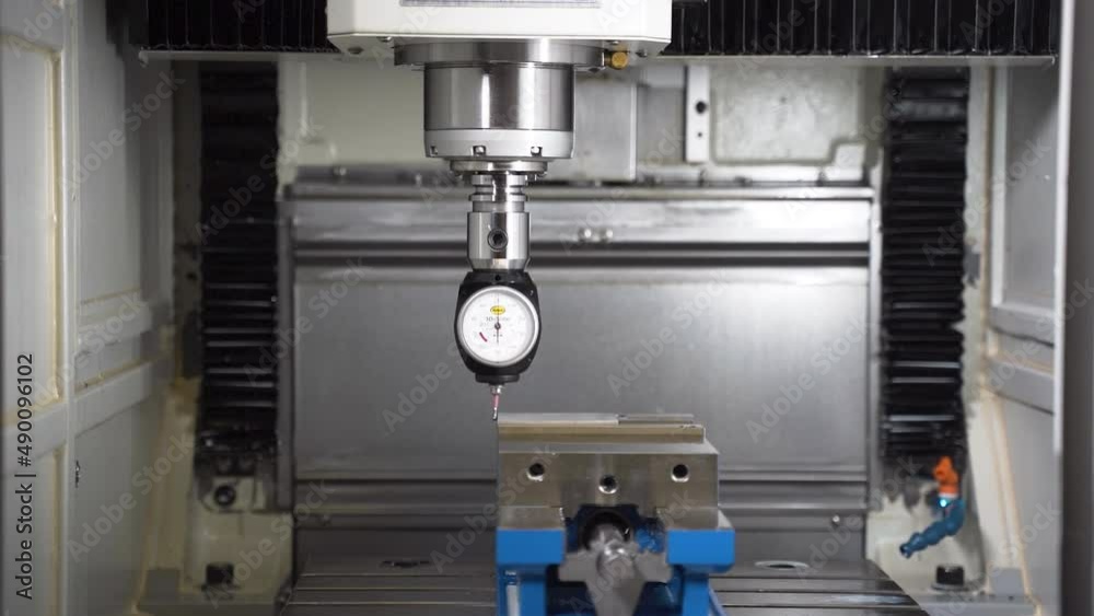 CNC machine 3D Taster dial indicator measuring a steel part in a vice.
