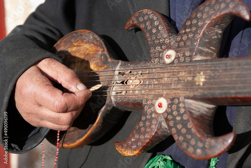 Man playing the Rawap, Traditional Uyghur musical instrument, Tashkurgan County, Xinjiang, China photo