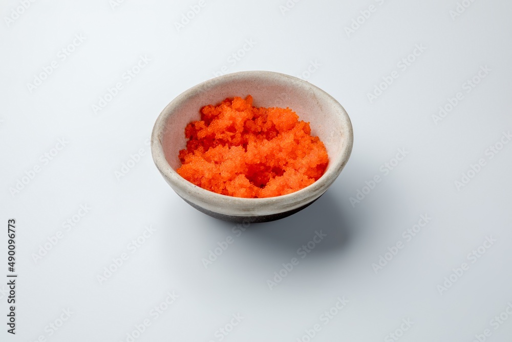 ceramic gravy boat with flying fish caviar tobiko on a white background ceramic gravy boat with flying fish caviar tobiko on a white background