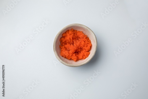 ceramic gravy boat with flying fish caviar tobiko on a white background