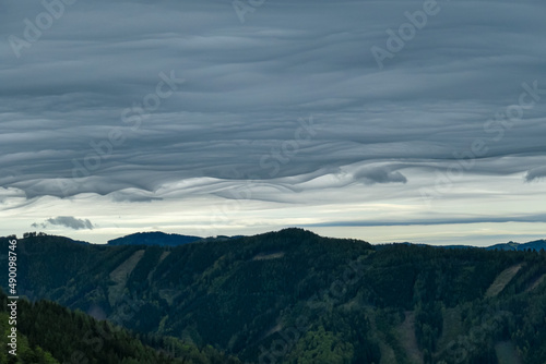 Mystical clouds and scenic view from mount Roethelstein near Mixnitz in Styria, Austria. Landscape of green alpine meadow and bushes in the valley of Grazer Bergland in Styria, Austria. Cloudscape