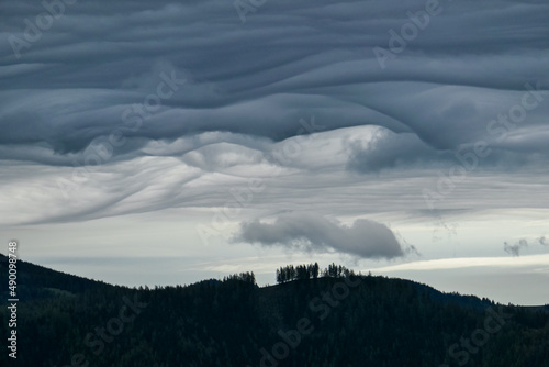 Mystical clouds and scenic view from mount Roethelstein near Mixnitz in Styria, Austria. Landscape of green alpine meadow and bushes in the valley of Grazer Bergland in Styria, Austria. Cloudscape photo