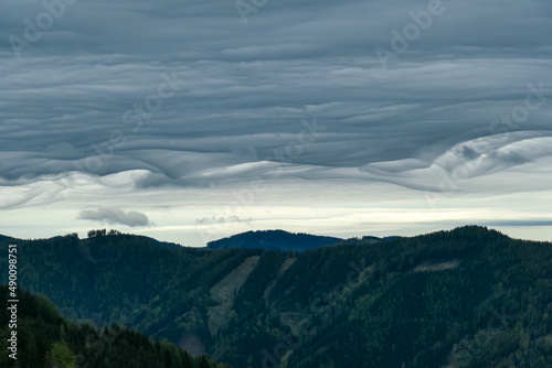 Mystical clouds and scenic view from mount Roethelstein near Mixnitz in Styria, Austria. Landscape of green alpine meadow and bushes in the valley of Grazer Bergland in Styria, Austria. Cloudscape photo