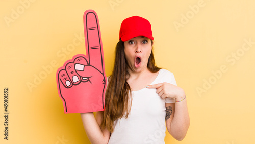 young pretty woman looking shocked and surprised with mouth wide open, pointing to self. number one hand concept photo