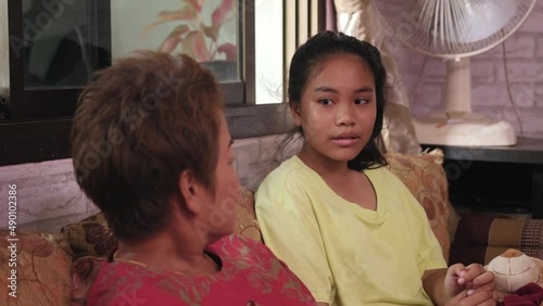 Mother talking with her daughter by sitting on couch Thailand Asian family
