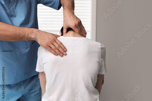 Orthopedist examining woman's neck in clinic, closeup. Scoliosis treatment