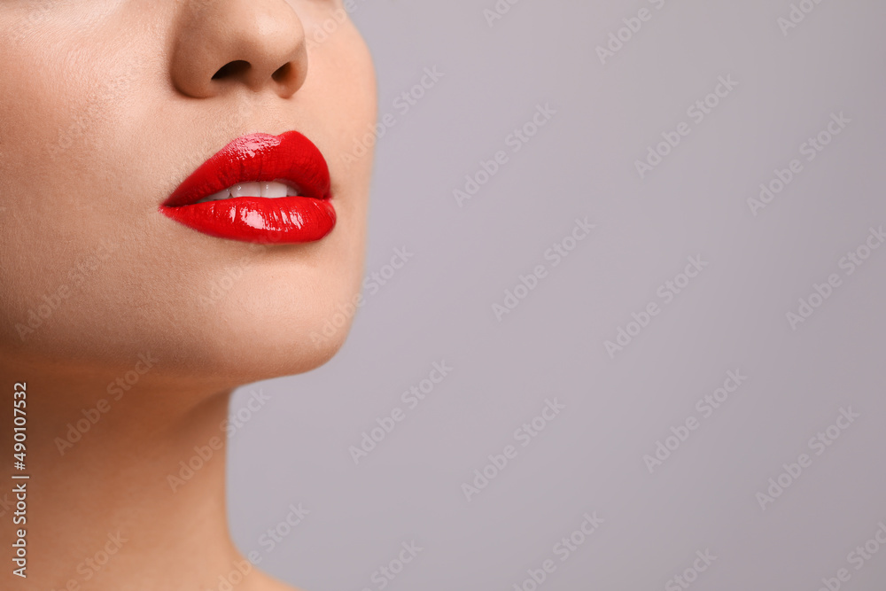 Fototapeta premium Closeup view of woman with beautiful full lips on grey background. Space for text