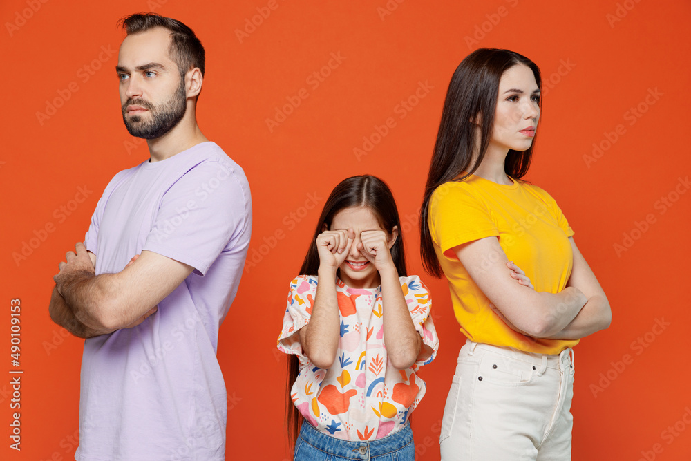 Young strict angry serious parents mom dad with sad crying child kid daughter teen girl wearing basic t-shirts isolated on yellow background studio portrait. Family day parenthood childhood concept Young strict angry serious parents mom dad with sad crying child kid daughter teen girl wearing basic t-shirts isolated on yellow background studio portrait. Family day parenthood childhood concept