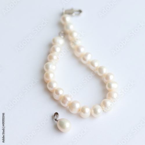 Pearl bracelet and pendant isolated on white background. 