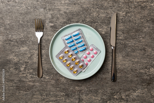 Many different weight loss pills and supplements as food on round plate. Pills served as a healthy meal. Drugs, pharmacy, medicine or medical healthycare concept photo