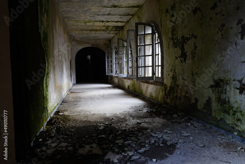 Abandoned building aisle with broken windows and ruined floor