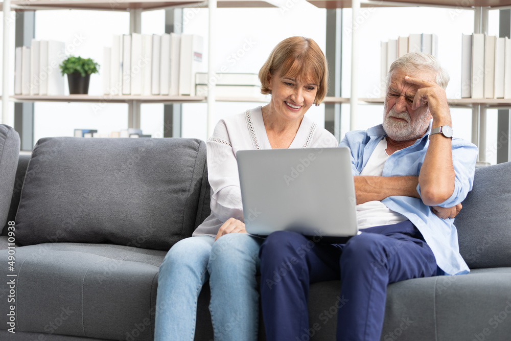 senior couple using laptop computer on sofa senior couple using laptop computer on sofa