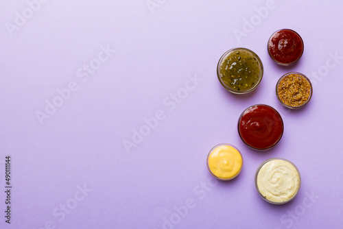 Different types of sauces in bowls on a colored Board . Top view. various sauces copy space