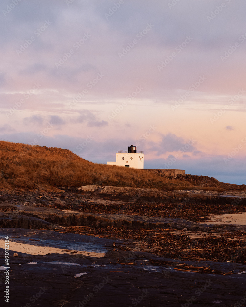 Bamburgh Lighthouse at sunrise on winter morning