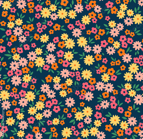 Beautiful floral pattern in small abstract flowers. Small colorful flowers. Dark Blue background. Ditsy print. Floral seamless background. The elegant the template for fashion prints. Stock pattern.