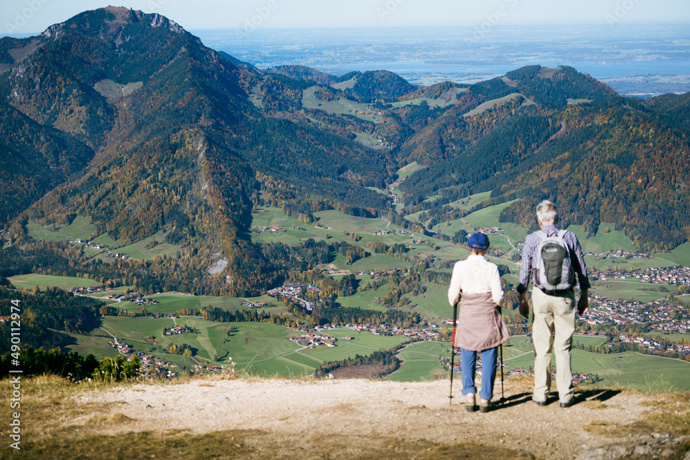 Zwei Wanderer blicken vom Berg ins Tal