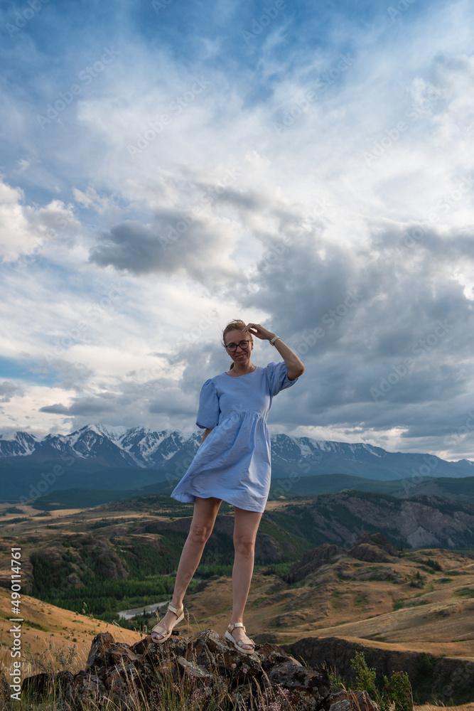 Woman in blue dress in summer Altai mountains in Kurai steppe Woman in blue dress in summer Altai mountains in Kurai steppe