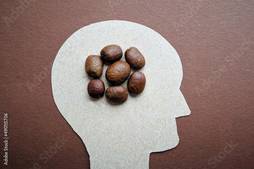 A man's head in profile with coffee instead of a brain, a profile of a man with poop instead of a brain. photo