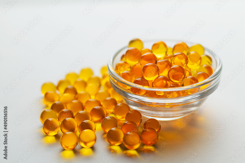 Omega 3 capsules on the white background. Fish oil in pills. Healthy vitamins and treatment. Biologically active additives. copy space.