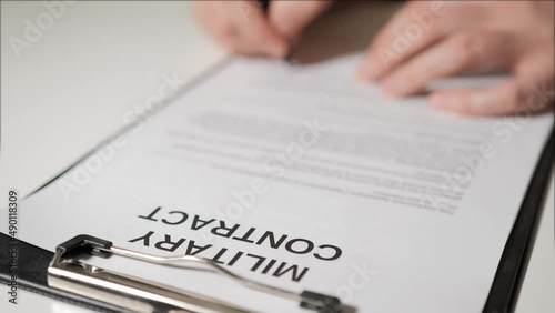 military contract. The hands of man sign military contract for military service. Agreement to participate in hostilities.