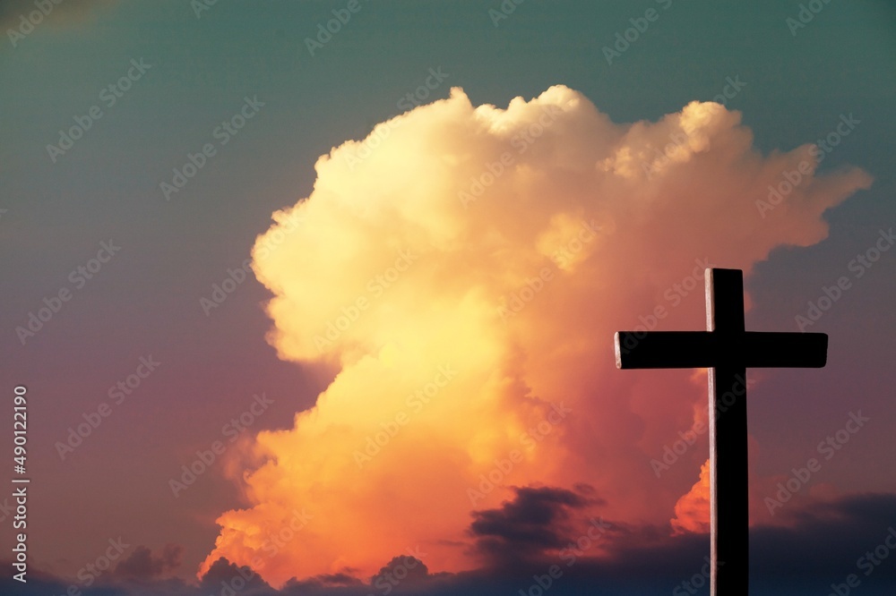 The wooden Cross at the sunset sky background The wooden Cross at the sunset sky background