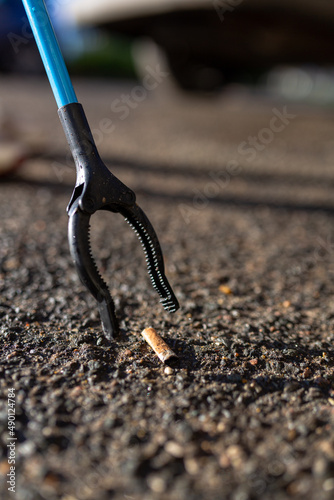 A close up of a cigarette butt that has been picked up by a litter picker. Litter pick, rubbish, environmental concept photo