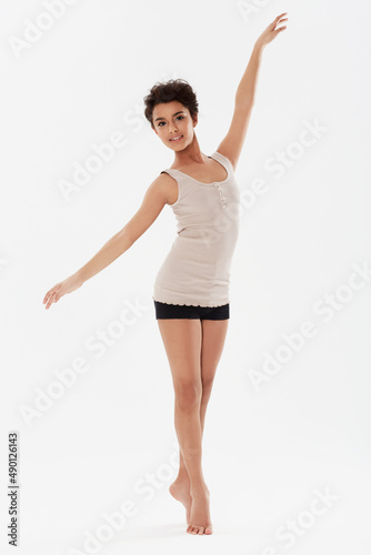 Shes one with the music. A beautiful ethnic woman dancing against a white background.