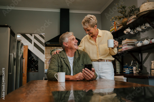 Caucasian elderly couple drinking coffee in kitchen 