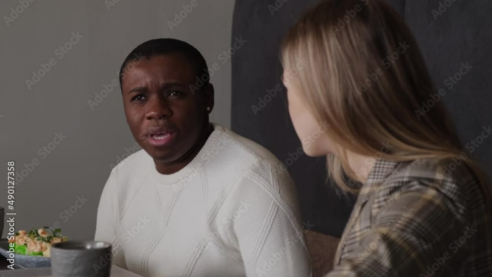 A blonde and a black guy are talking in a cafe A blonde and a black guy are talking in a cafe
