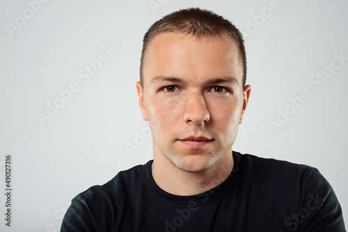 Portrait of a serious casual man standing on a white background © Bogdan