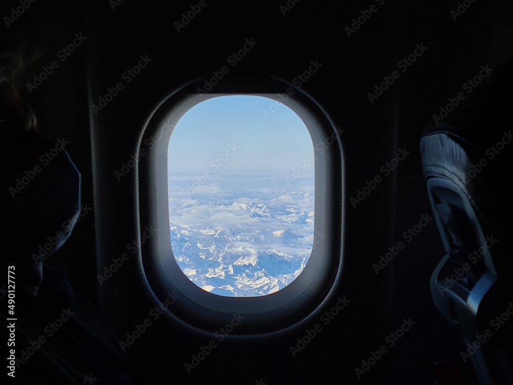 Panorama of the snow capped Alps in the window of an airplane flying over them Panorama of the snow capped Alps in the window of an airplane flying over them