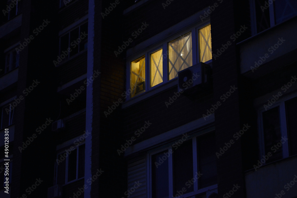 Kyiv/Ukraine - 28 February 2022: War Ukraine Russia. Light in the window at night, which is taped to prevent the formation of broken glass.