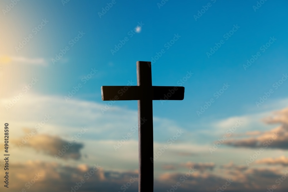 The wooden Cross at the sunset sky background The wooden Cross at the sunset sky background