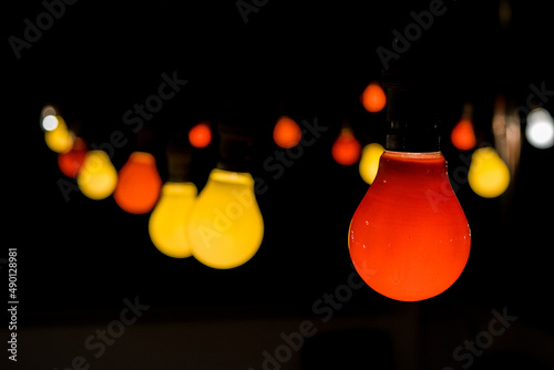 A festoon with red and yellow light bulbs lit up during a party celebration to create festive mood