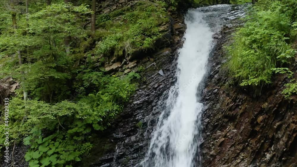 Drone flight over the Guk waterfall on the Zhenets river, under the Khomyak mountain in Gorgan, Carpathians, Ukraine. Wild coniferous forest and clear water of a mountain river. Drone flight over the Guk waterfall on the Zhenets river, under the Khomyak mountain in Gorgan, Carpathians, Ukraine. Wild coniferous forest and clear water of a mountain river.